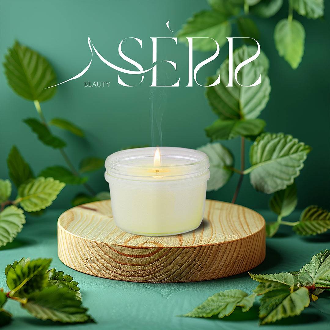 SerrBeauty Peppermint Beeswax Scented Candle 125 G in a frosted glass jar, placed on a wooden stand, surrounded by fresh peppermint leaves. Made from organic beeswax, this eco-friendly candle offers a refreshing and calming peppermint aroma for relaxation and mental clarity.