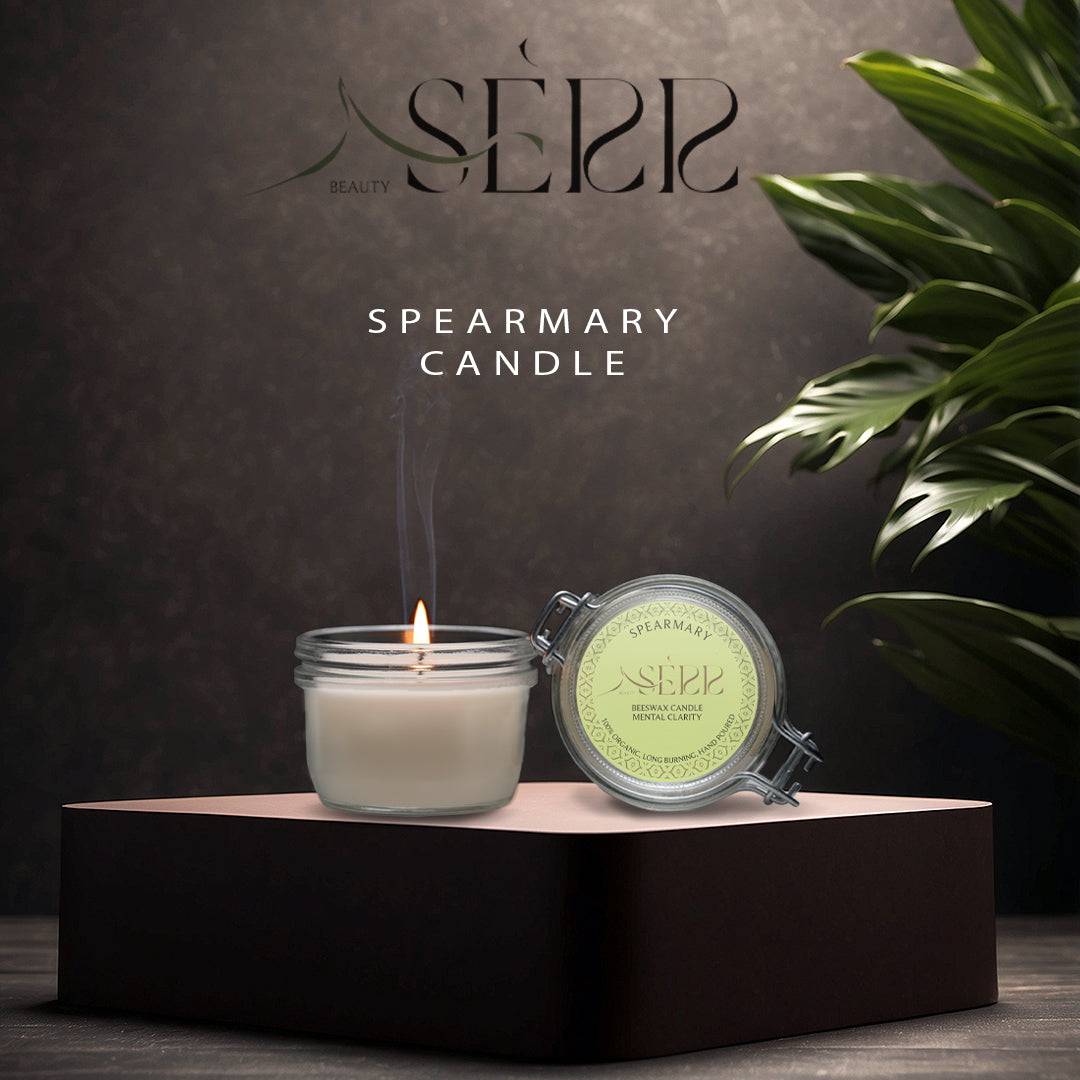 SerrBeauty Spearmary Beeswax Scented Candle 125 G in a glass jar with a lit wick, placed on a black pedestal. Infused with rosemary and spearmint for a refreshing aroma.