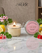 SerrBeauty geranium and lemon beeswax candle 125g burning in a glass jar with floral citrus styling