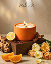 Orange concrete candle with wood wicks, surrounded by orange, flowers and spices, cozy home ambiance