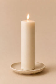 Everyday unscented rapeseed wax pillar candle 125g burning on a ceramic plate