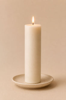 Everyday unscented rapeseed wax pillar candle 125g burning on a ceramic plate