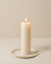 Everyday unscented rapeseed wax pillar candle 44g burning on a ceramic plate