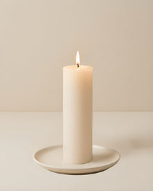 Everyday unscented rapeseed wax pillar candle 44g burning on a ceramic plate